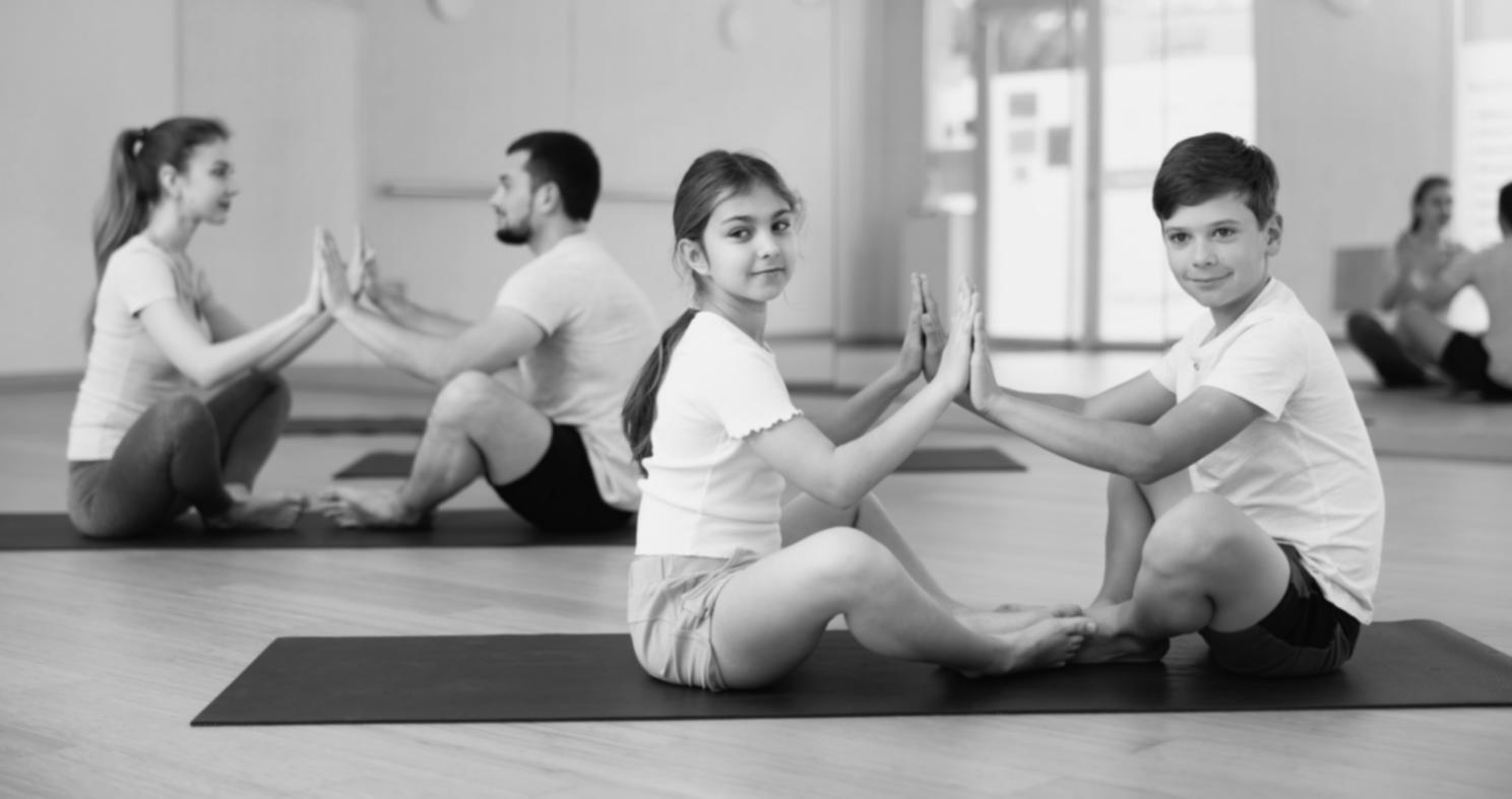 Group yoga session showing participants practising a standing balance pose